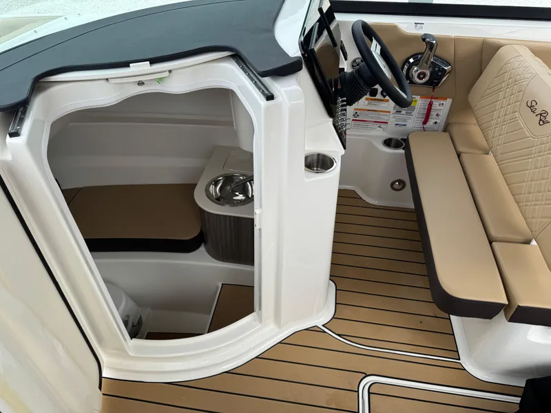 Slide: The Image of 2025 Sea Ray SDX 250 boat interior with seating, helm, and cabin entrance. - 17