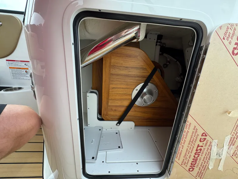 Slide: The Image of Storage compartment on a 2025 Sea Ray SDX 250 boat, featuring wooden interior details. - 18