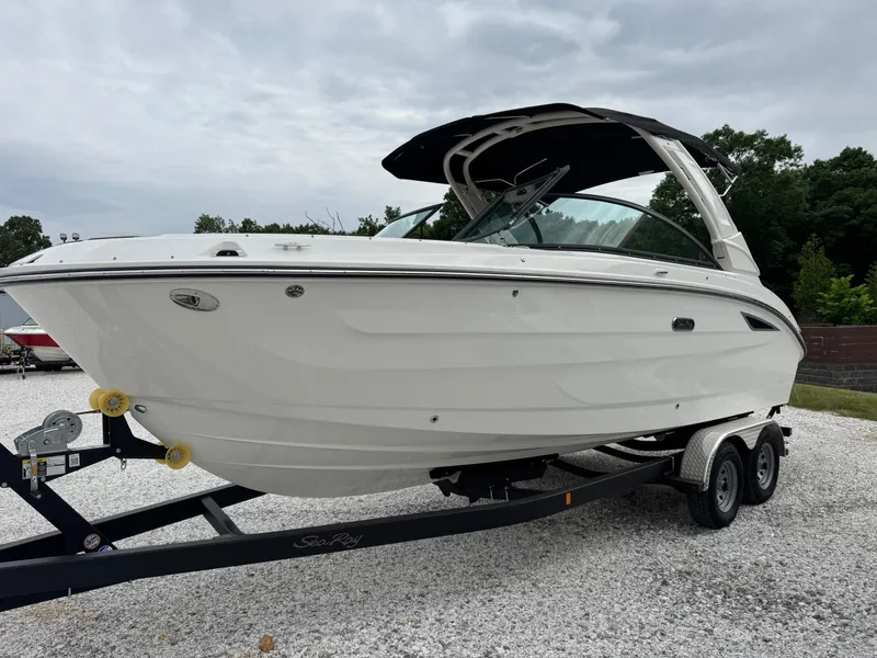 Slide: The Image of 2025 Sea Ray SDX 250 boat on trailer, parked on gravel, under cloudy sky. - 5