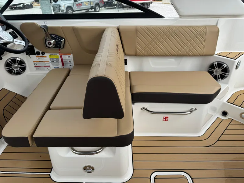 Slide: The Image of 2025 Sea Ray SDX 250 boat interior with tan seating and wood-style flooring. - 9