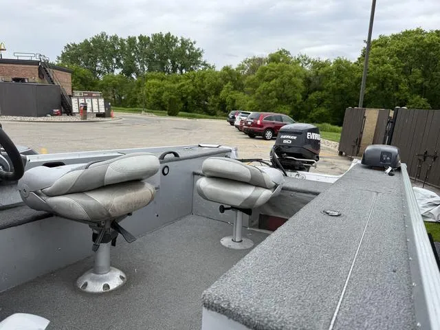 Slide: The Image of 2007 Alumacraft Lunker 165CS boat interior with seating and Evinrude motor in parking lot. - 11