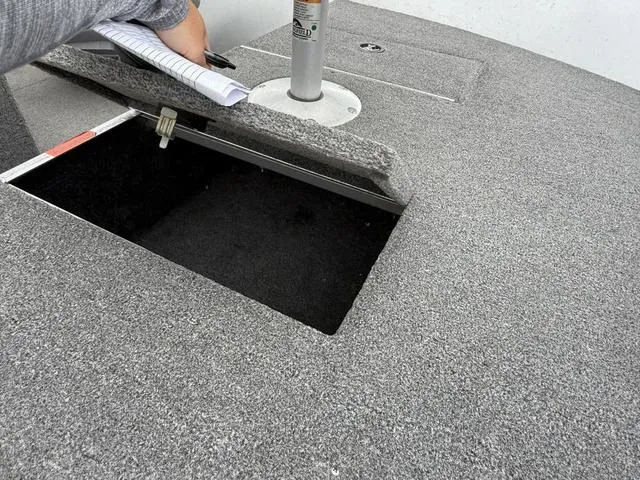 Slide: The Image of 2007 Alumacraft Lunker 165CS boat storage compartment with open hatch and gray textured surface. - 8