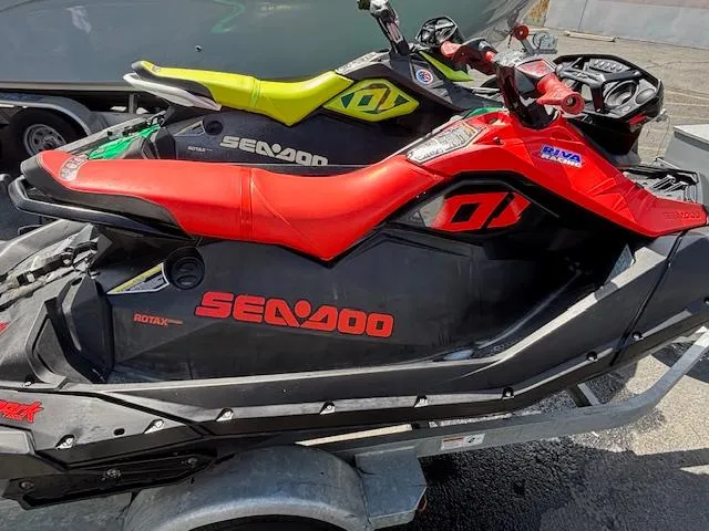 Slide: The Image of 2021 Sea-Doo SPARK TRIXX 3up jet skis on a trailer, vibrant red and yellow designs. - 4