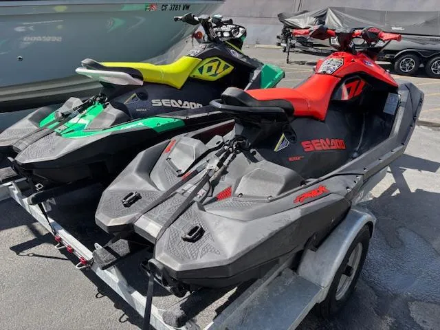 Slide: The Image of 2021 Sea-Doo SPARK TRIXX 3up jet skis on trailer, vibrant colors, outdoor setting. - 5
