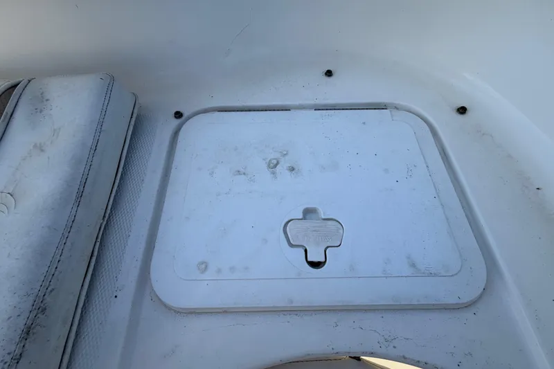 Slide: The Image of 2008 Sea Fox 216 Dual Console storage compartment with seat cushion, showing wear and dirt. - 50