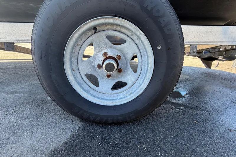 Slide: The Image of Trailer wheel of a 2008 Sea Fox 216 Dual Console boat on wet pavement. - 54