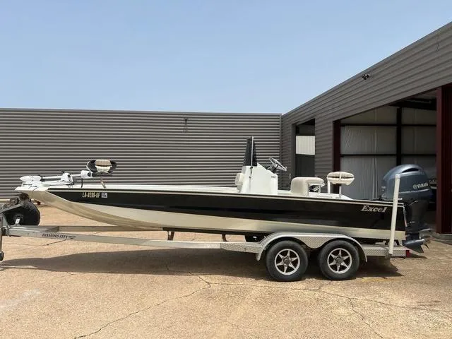 Slide: The Image of 2017 Excel 22' Pleasure boat on trailer, parked near a metal building. - 2