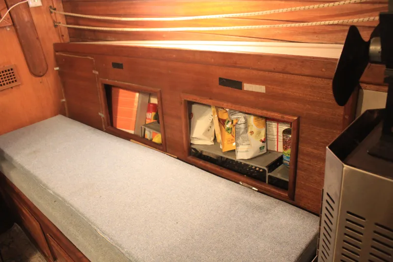 Slide: The Image of 1973 Challenger Cruiser interior with wooden storage and cushioned seating. - 16