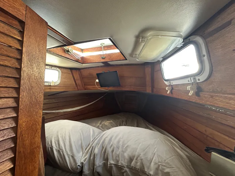Slide: The Image of 1973 Challenger Cruiser cabin interior with wooden paneling and cozy bedding. - 17
