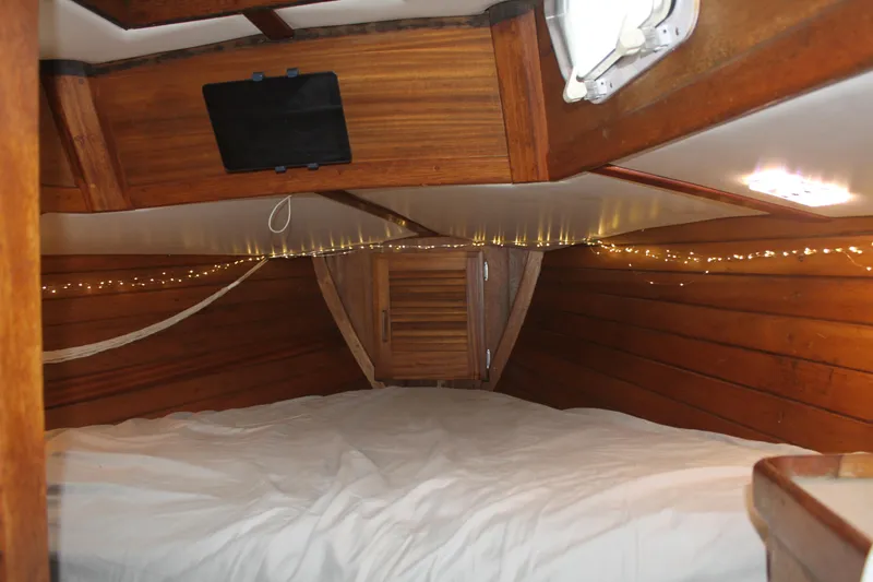 Slide: The Image of Cozy wooden interior of a 1973 Challenger Cruiser boat cabin with string lights. - 18