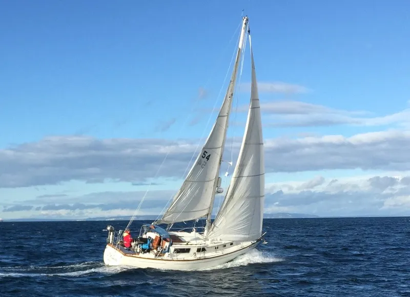 Slide: The Image of 1973 Challenger Cruiser sailboat navigating open sea under clear blue sky. - 2