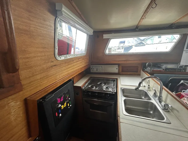 Slide: The Image of 1973 Challenger Cruiser kitchen with stove, double sink, and wooden interior. - 21