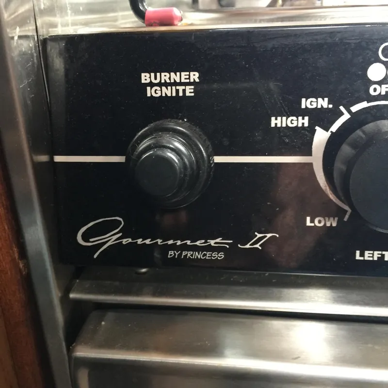 Slide: The Image of 1973 Challenger Cruiser stove control panel with burner ignite and temperature settings. - 25