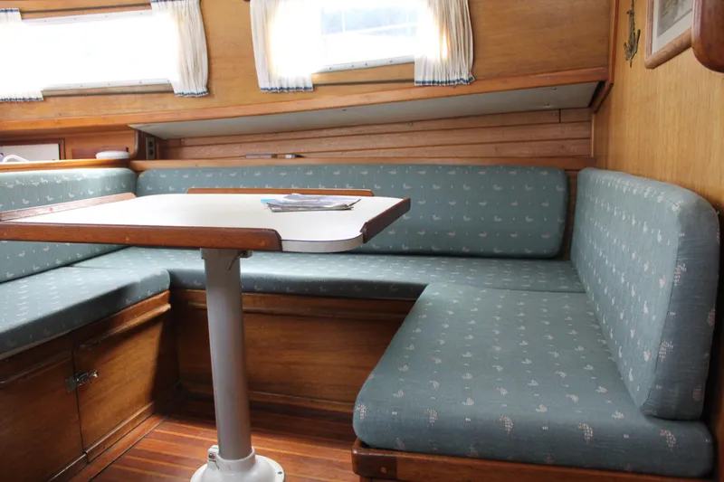 Slide: The Image of 1973 Challenger Cruiser interior with blue cushioned seating and wooden table. - 28