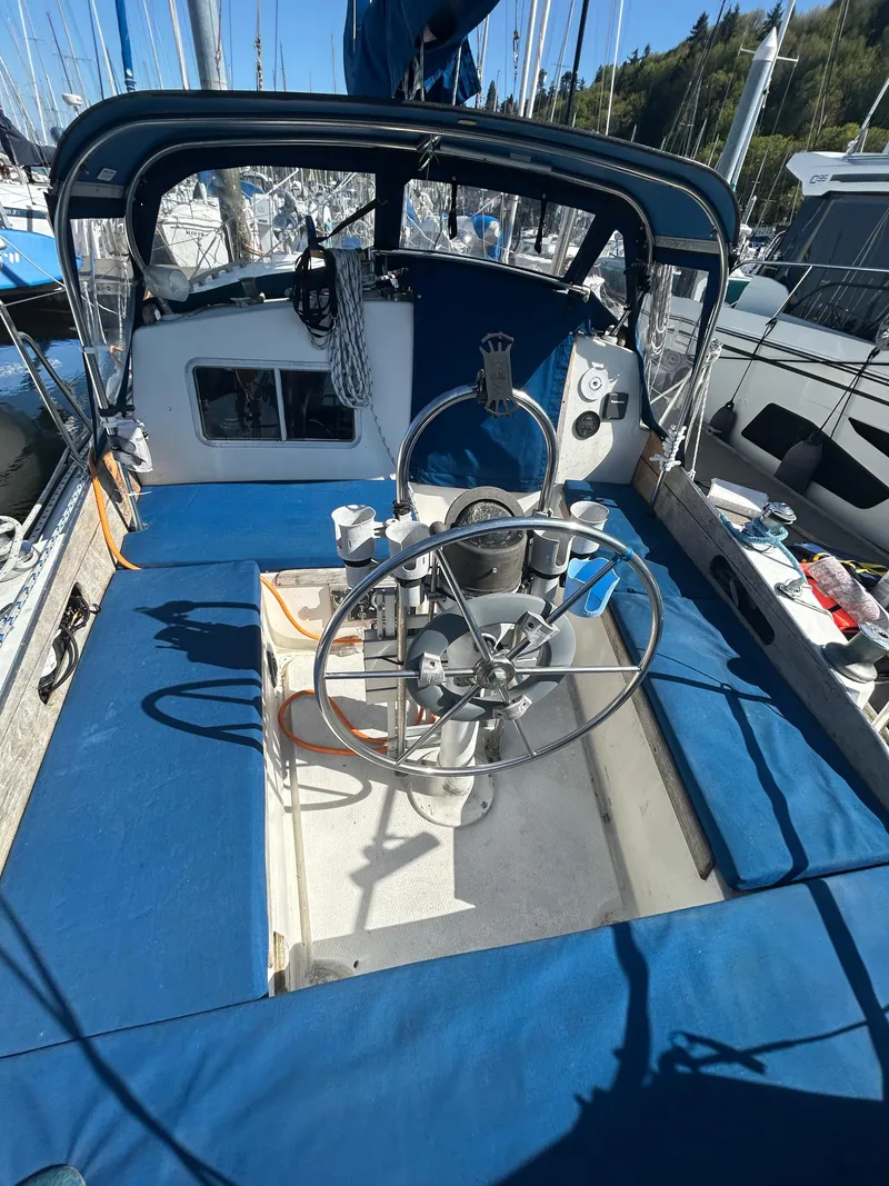 Slide: The Image of 1973 Challenger Cruiser sailboat cockpit with steering wheel and blue seating. - 3