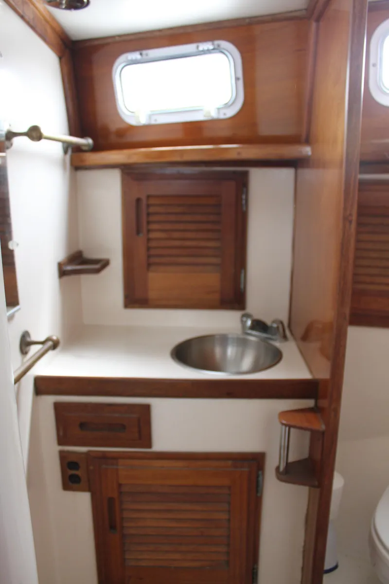 Slide: The Image of 1973 Challenger Cruiser bathroom with wooden cabinets and stainless steel sink. - 36