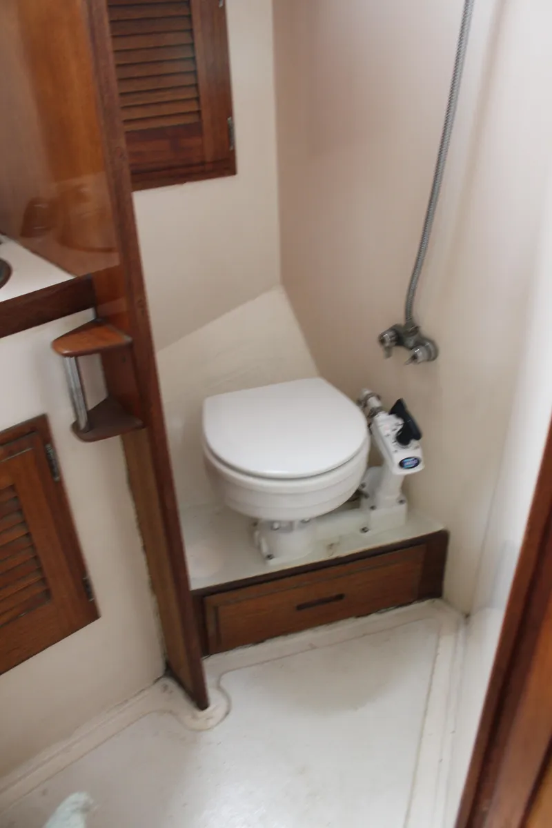Slide: The Image of 1973 Challenger Cruiser bathroom with compact toilet and wooden accents. - 38