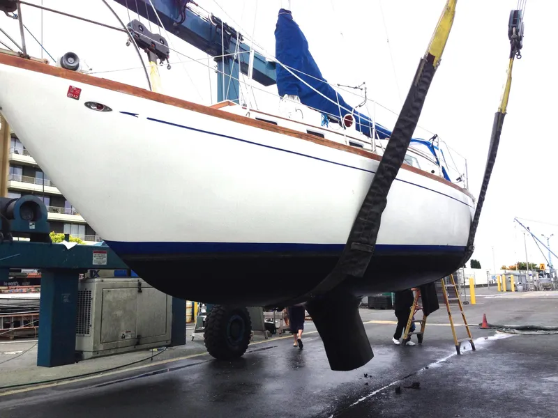 Slide: The Image of 1973 Challenger Cruiser sailboat being lifted at a marina. - 4