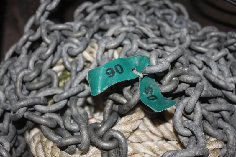 Slide: The Image of Heavy metal chains with green tags labeled "90" and "05" intertwined with rope. - 40