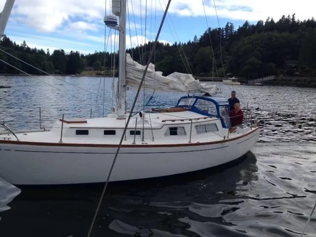 Slide: The Image of 1973 Challenger Cruiser sailboat on a calm lake with forested shoreline. - 47