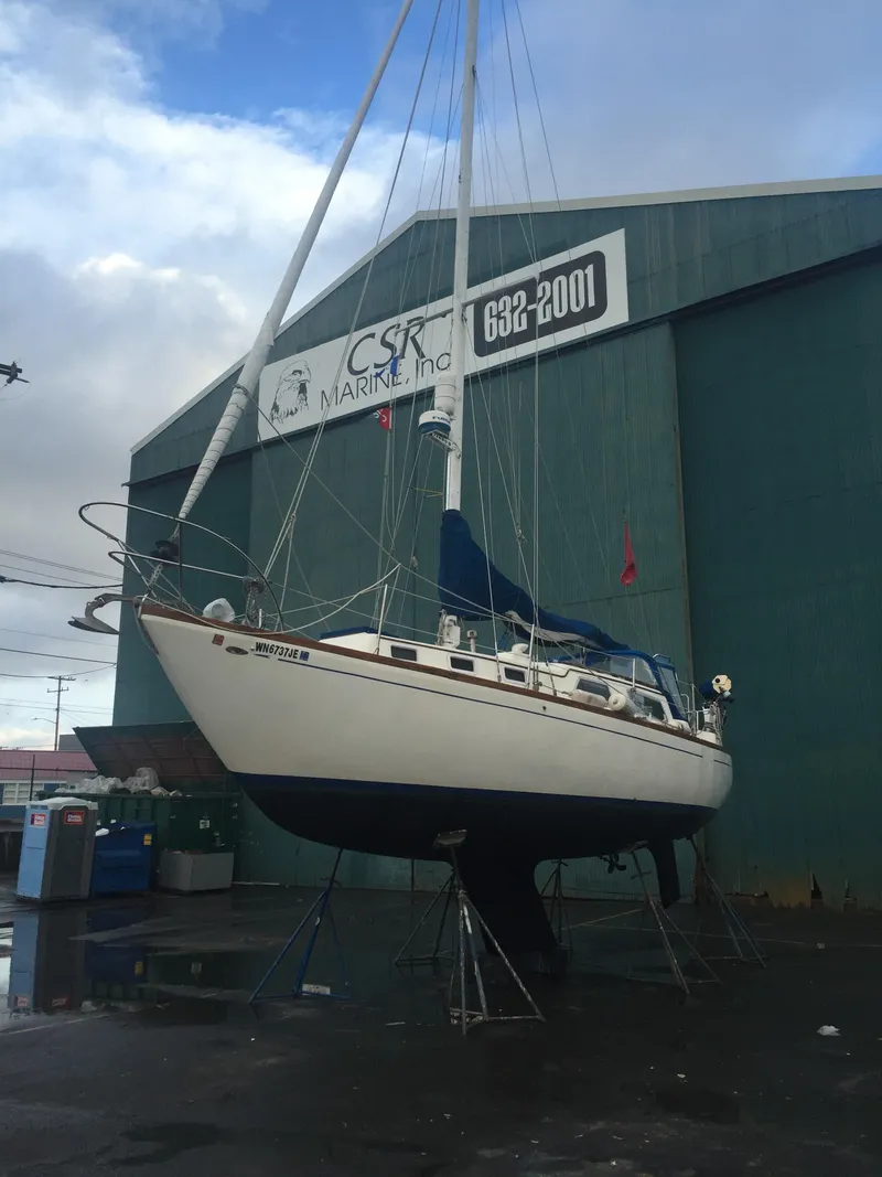 Slide: The Image of 1973 Challenger Cruiser sailboat on stands outside a marine service building. - 6