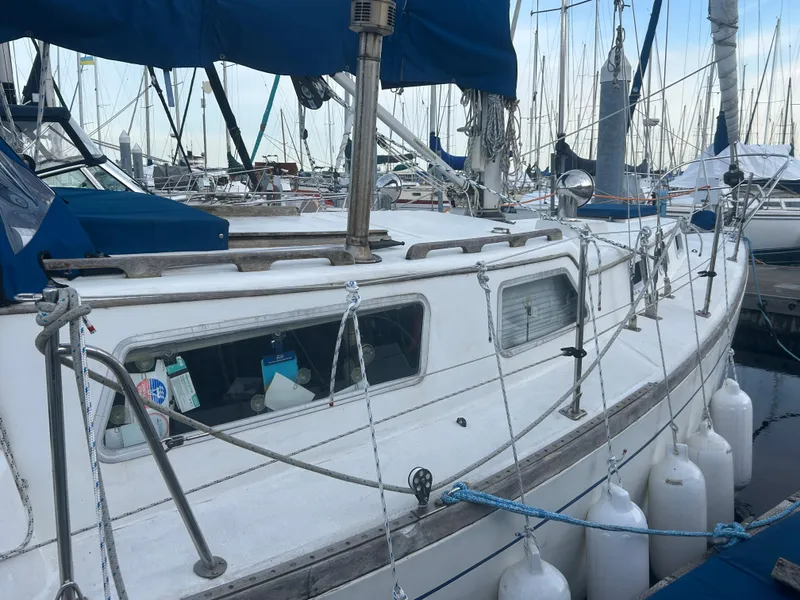 Slide: The Image of 1973 Challenger Cruiser sailboat docked at marina with blue canopy and fenders. - 7