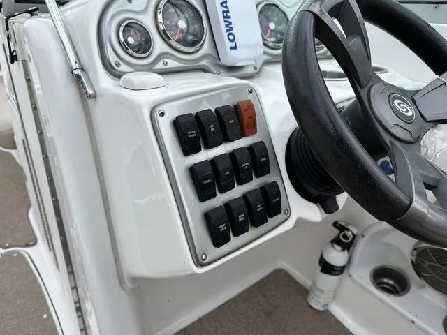 Slide: The Image of Control panel of a 2015 Hurricane SD 2400 I/O boat with steering wheel and switches. - 23