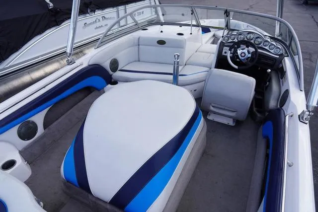Slide: The Image of 2004 Supra COMP LTS/SK boat interior with blue and white seating and modern dashboard. - 11