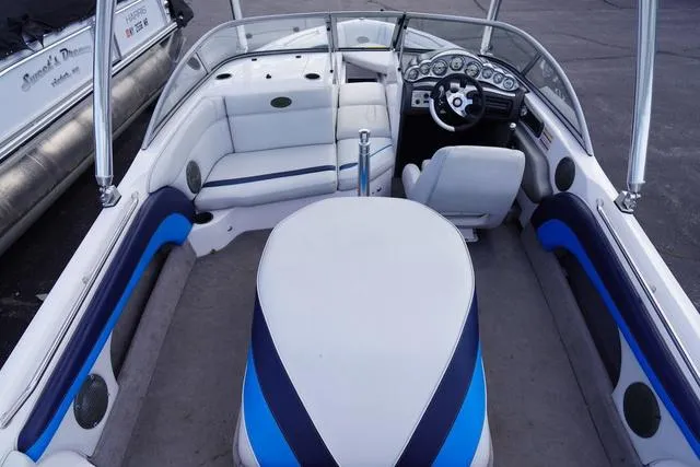 Slide: The Image of 2004 Supra COMP LTS/SK boat interior with white and blue seating and steering console. - 9