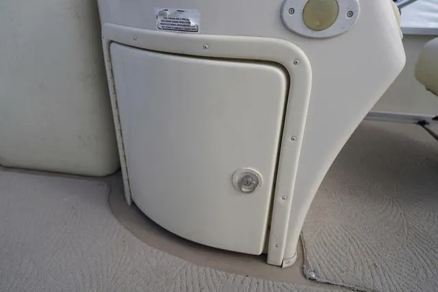 Slide: The Image of 2008 Bennington 2250 boat storage compartment with beige finish and secure latch. - 10