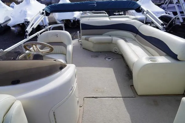 Slide: The Image of 2008 Bennington 2250 pontoon boat interior with beige seating and blue accents. - 12
