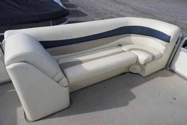 Slide: The Image of 2008 Bennington 2250 boat seating with white and blue upholstery, outdoor setting. - 24
