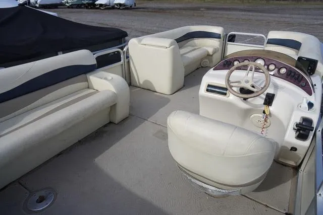 Slide: The Image of 2008 Bennington 2250 pontoon boat interior with beige seating and steering console. - 8