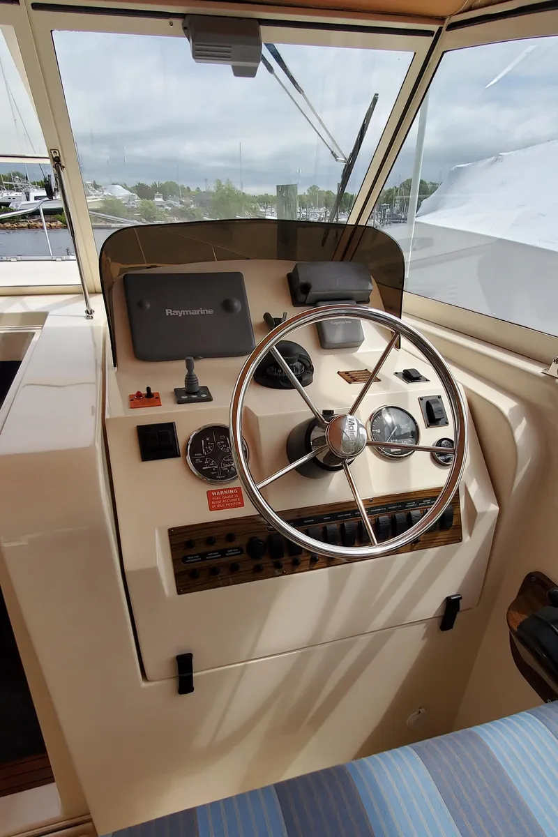 Slide: The Image of Helm of 2006 Mainship 34 Rum Runner Classic with steering wheel and navigation instruments. - 10