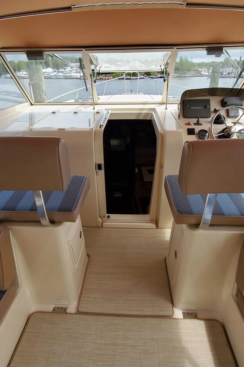 Slide: The Image of 2006 Mainship 34 Rum Runner Classic boat interior with helm and seating area. - 12