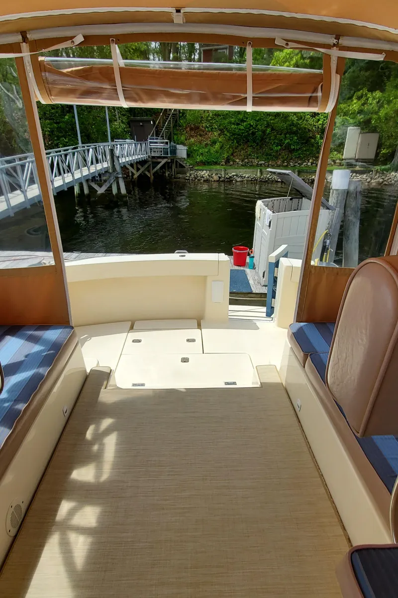Slide: The Image of 2006 Mainship 34 Rum Runner Classic boat interior, docked by a scenic waterfront. - 13
