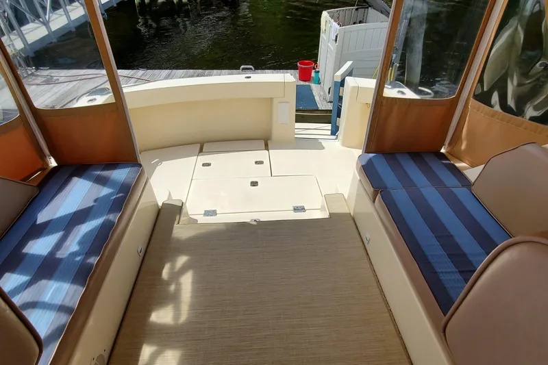 Slide: The Image of 2006 Mainship 34 Rum Runner Classic boat interior with striped seating and open deck. - 15