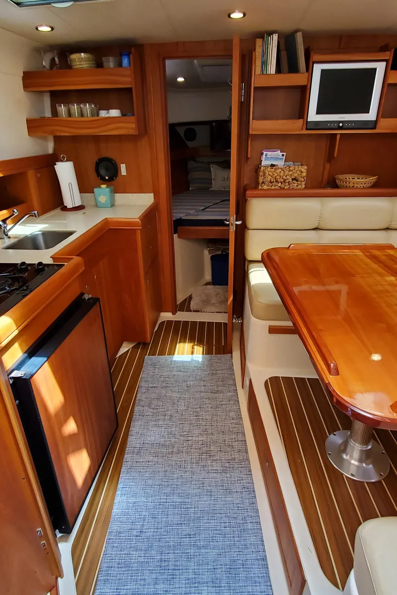 Slide: The Image of 2006 Mainship 34 Rum Runner classic yacht interior with wood finish and modern amenities. - 17