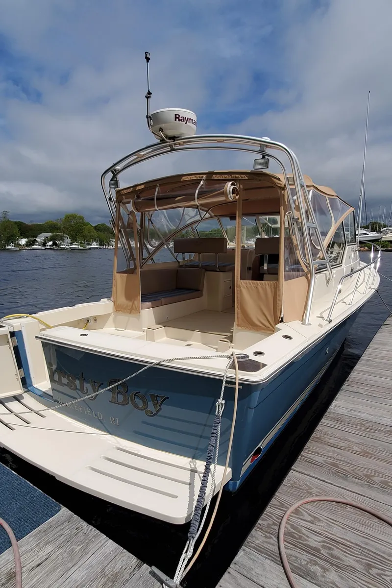 Slide: The Image of 2006 Mainship 34 Rum Runner Classic boat docked by the water. - 2