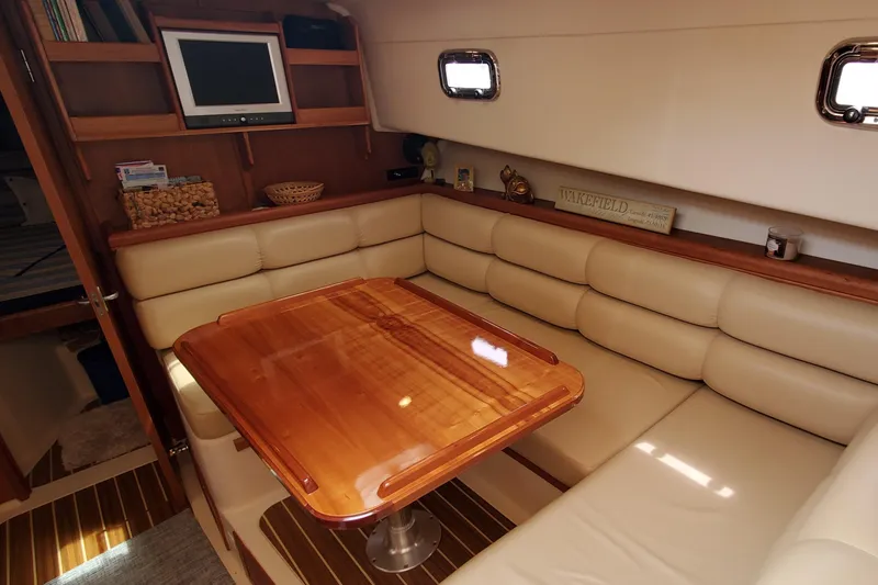 Slide: The Image of 2006 Mainship 34 Rum Runner classic interior with cozy seating and wooden table. - 20