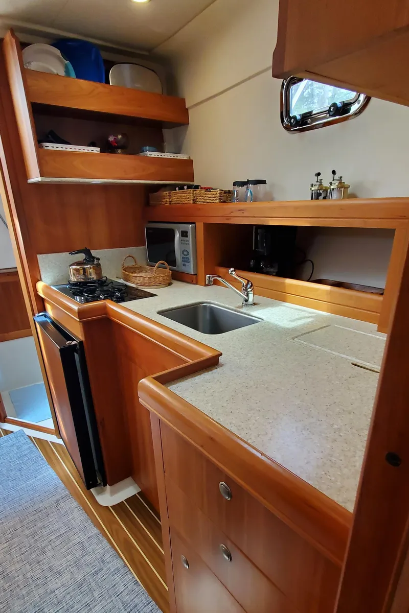 Slide: The Image of 2006 Mainship 34 Rum Runner classic yacht kitchen with wood cabinetry and modern appliances. - 24