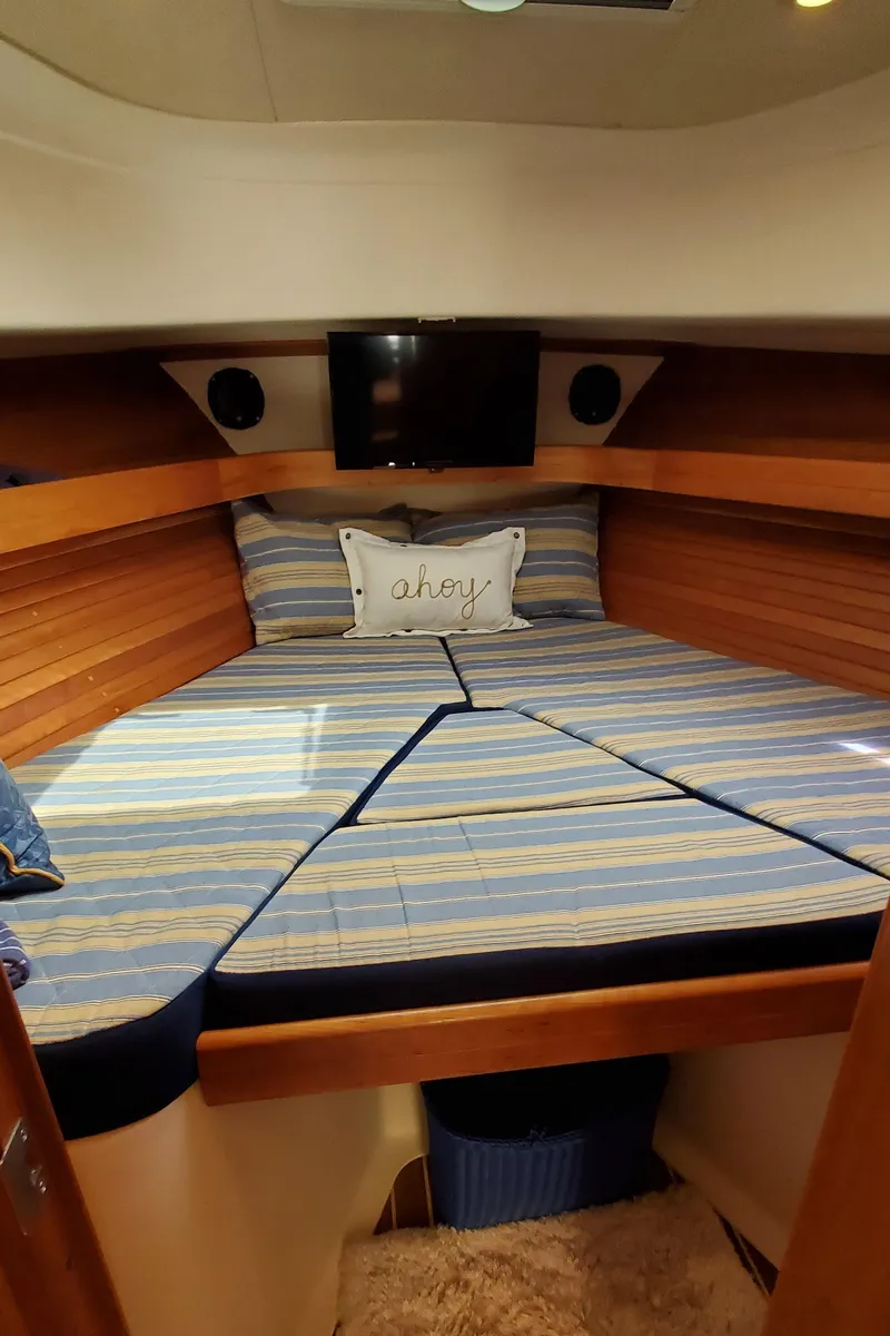 Slide: The Image of 2006 Mainship 34 Rum Runner classic cabin with striped bedding and cozy decor. - 25