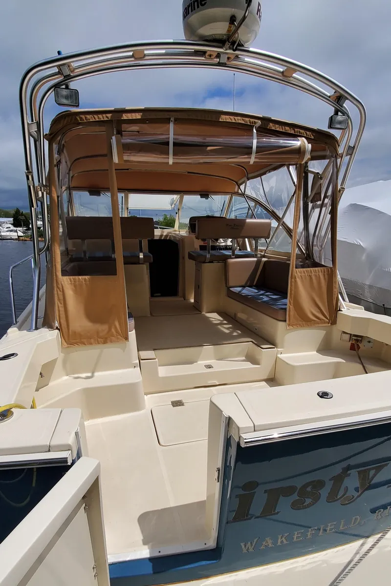Slide: The Image of 2006 Mainship 34 Rum Runner Classic boat with tan canopy and spacious deck. - 3