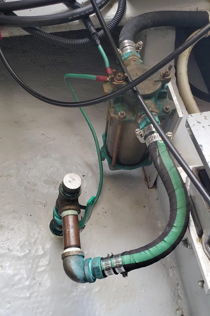 Slide: The Image of Engine compartment of 2006 Mainship 34 Rum Runner classic with visible hoses and fittings. - 34