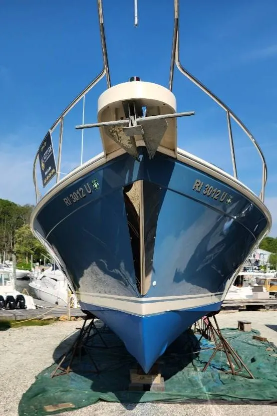 Slide: The Image of 2006 Mainship 34 Rum Runner Classic boat on dry dock, blue hull, sunny day. - 40