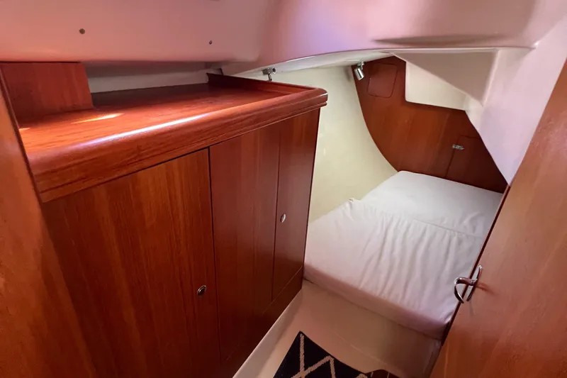 Slide: The Image of 2005 Hunter 33 yacht cabin with wooden cabinetry and cozy sleeping area. - 10