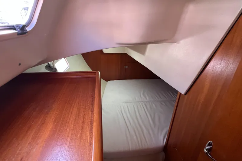 Slide: The Image of 2005 Hunter 33 yacht interior cabin with wooden finish and bed. - 11