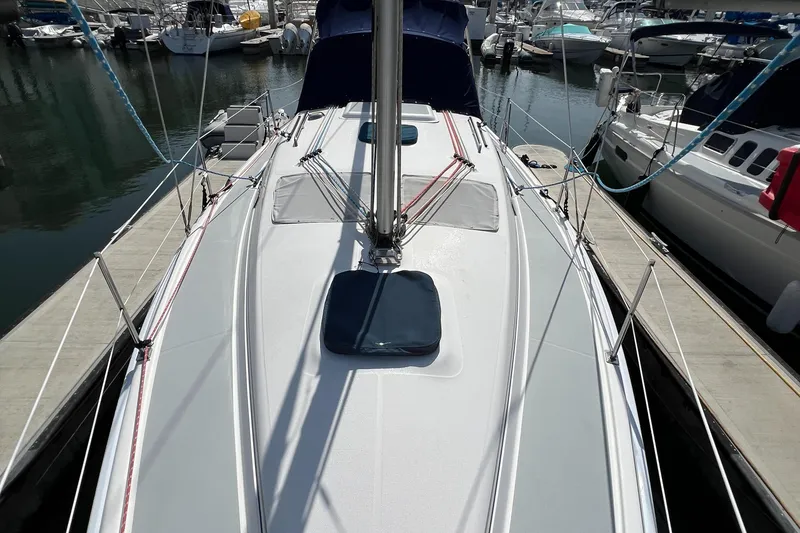 Slide: The Image of 2005 Hunter 33 sailboat docked at marina, showcasing deck and mast. - 2
