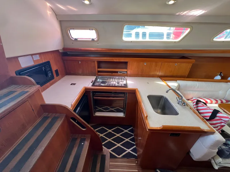 Slide: The Image of Interior of 2005 Hunter 33 sailboat kitchen with stove, sink, and wooden cabinetry. - 4