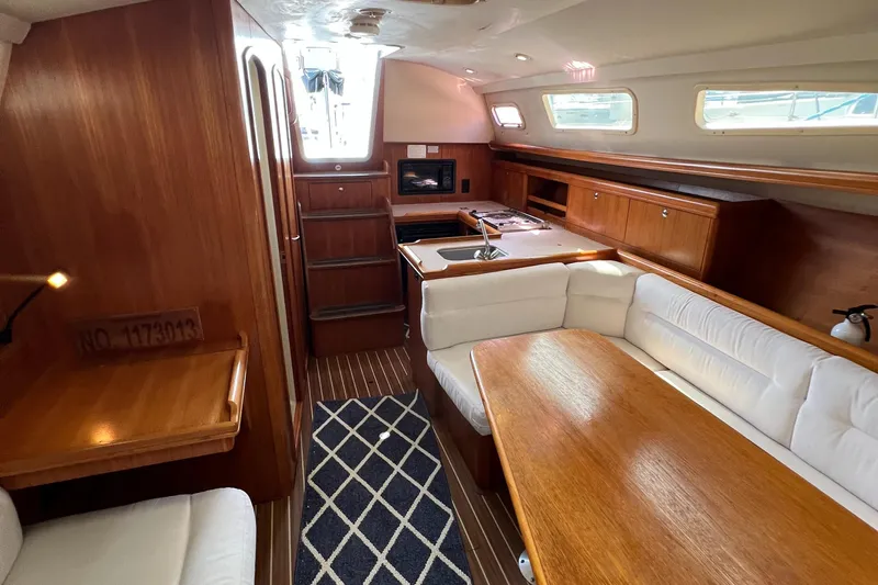 Slide: The Image of Interior of 2005 Hunter 33 sailboat with wood finish and cozy seating area. - 7